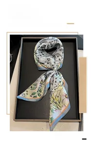 Detail of 53cm mulberry silk scarf with floral print and pearl ring buckle on black tray