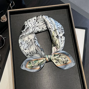 Elegant grey-blue silk neck scarf with floral print and gold contrast hem in a bow style