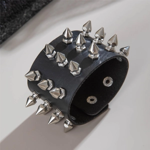 Detail of black punk leather bracelet with three rows of silver cone spike rivets