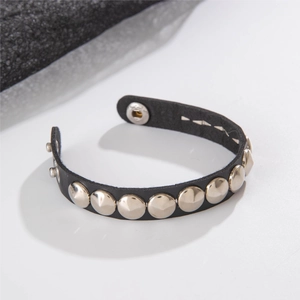 Close-up of punk black leather bracelet with silver metal rivets and snap fastener