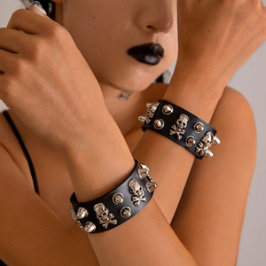 Punk black leather bracelet set with silver skulls and conical spikes on a model