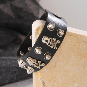 Detailed view of punk leather bracelet with silver skull studs and metal rivets