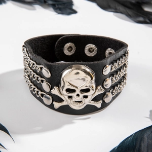 Macro shot of punk black leather cuff bracelet with silver skull and metal triple chains