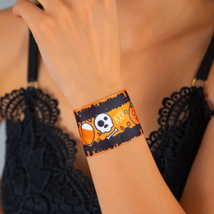 Close-up of Halloween fabric wristband with skull and pumpkin patterns on wrist