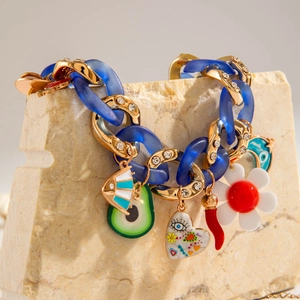 Chunky acrylic chain necklace with evil eye and heart charms on a stone display