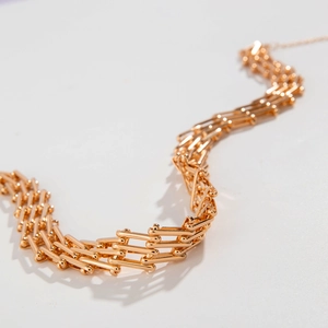 Detail der goldenen mechanischen Gliederkette mit filigraner Netzstruktur und Metalltextur