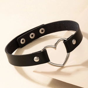 Dettaglio choker in pelle nera con grande anello a cuore argento e bottoni a pressione