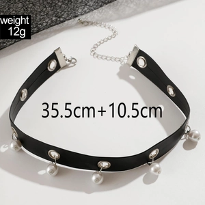 Dettaglio del choker punk con occhielli metallici e cinque perle su nastro di velluto