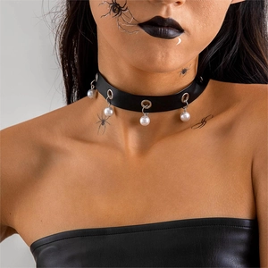 Dettaglio di un choker in velluto nero con occhielli d'argento e perle bianche appese