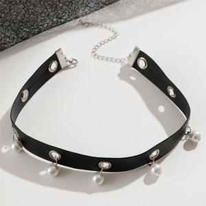 Dettaglio di un choker in pelle nera punk con occhielli argentati e perle bianche