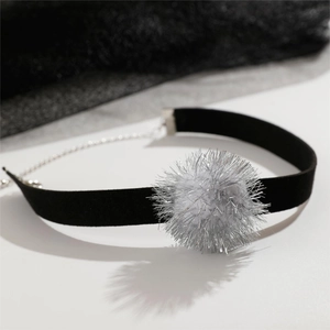 Dettaglio choker in velluto nero con pompon glitterato argento e chiusura in metallo