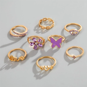 Detailed set of 8 gold-tone rings featuring purple enamel butterfly and LOVE hollow design