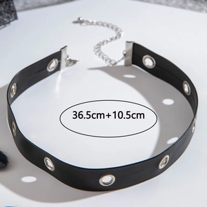 Dettaglio di un choker punk nero con occhielli in metallo argento e catena regolabile