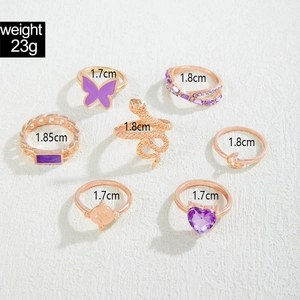 Detailed view of purple butterfly and gold snake rings with size markers for women
