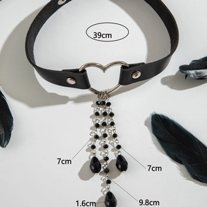 Dettaglio choker in pelle gotica con anello a cuore e catenelle con perline