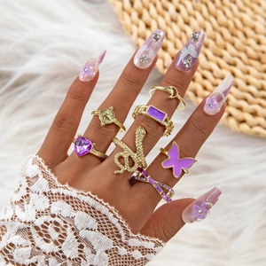 8-piece gold butterfly and snake ring set with purple heart stones worn on hand