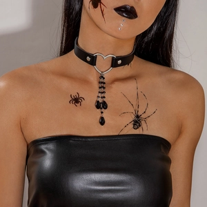 Dettaglio del choker gotico in pelle con anello a cuore d'argento e perle pendenti