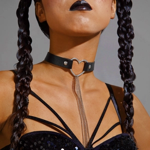 Dettaglio di un choker in pelle nera con cuore e catene metalliche in stile punk gothic