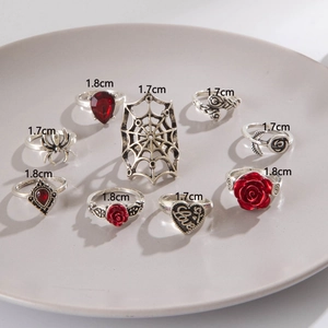 Macro detail of 9-piece punk ring set with spider and rose motifs in silver finish