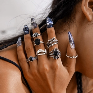 Close-up of gothic silver ring set with black gemstone and skull motifs on hand