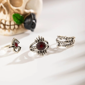 Gothic silver ring set with red crystal spider and crown details in dark aesthetic lighting