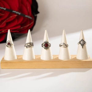 Detail of gothic silver rings set with red gemstone and spider patterns on wooden stands
