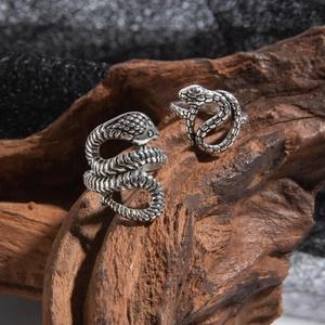 Macro shot of two vintage silver snake rings with textured scales and oxidation details