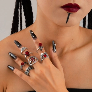 Close-up of Gothic silver rings featuring red roses, skulls and coffins on hand