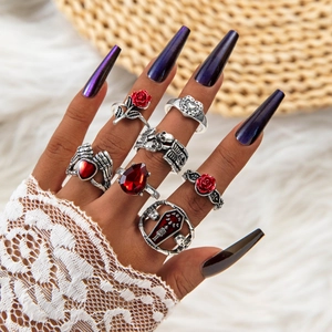 Close-up of gothic ring set with red rhinestones, skull and rose motifs on hand