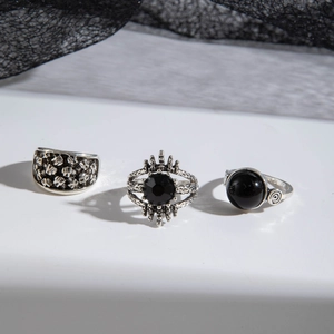 Close-up of punk Gothic ring set with skull relief and black stones on lace background