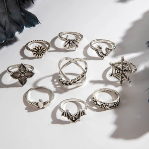 Detailed view of 9-piece gothic ring set with spider, rose and bat motifs in antique silver