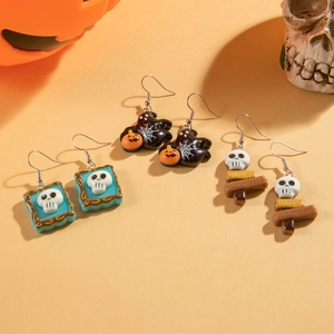 Detail of Halloween drop earrings featuring skull designs and Happy Halloween text