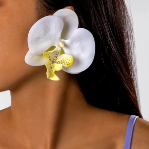 Close-up of elegant cream orchid earrings with realistic petal textures on model