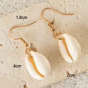 Detail shot of bohemian shell earrings with golden hooks and clear size measurements