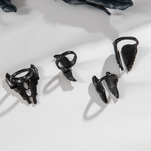 Gothic black angel wing ring set with punk feather elements on white surface