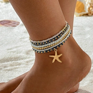 Bohemian multi-layer beach anklet with colorful beads and golden starfish charm on sand