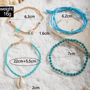 Detail view of 4-piece beach anklet set featuring shells and starfish on white sand