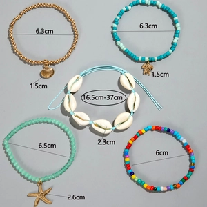 Detail view of colorful bohemian beach anklets with starfish, turtle and seashell charms