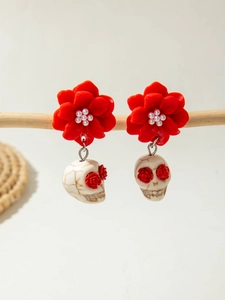 Detail of gothic camellia earrings with red petals, pearls and white skull pendants
