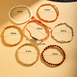 Detail view of 7-piece bohemian anklet set with colorful beads and metal leaf charm