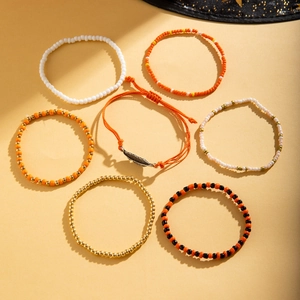 Detail view of 7-piece Bohemian colorful beaded anklets with starfish and leaf charms