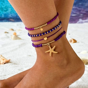 Close-up of Bohemian layered beach anklets with starfish charms and colorful seed beads