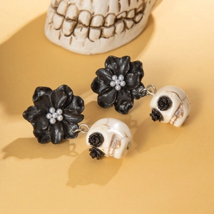 Gothic skull and camellia flower earrings with pearls on a warm vintage background