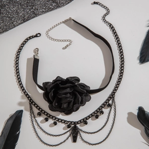 Detail of gothic black rose lace choker with coffin pendant and layered metal chains