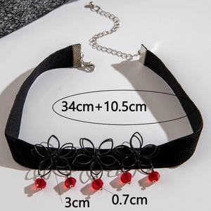 Detail of gothic black lace choker with red crystal drops and velvet flower accents