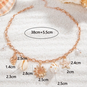 Bohemian gold starfish seashell pendant necklace displayed on a white sand beach background