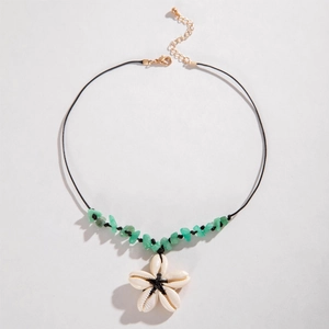 Detailed shot of white shell flower and green mineral stones on a woven cord necklace