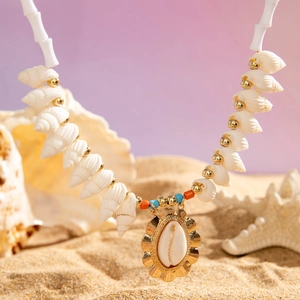 Close-up of bohemian shell necklace with starfish pendant on a sandy beach background