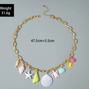 Detail of colorful marine charms on gold chain showing starfish, shell and seahorse pendants