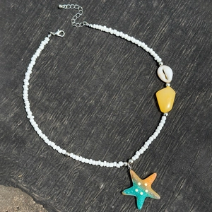Detail of beaded beach necklace featuring starfish pendant, seashell, and colorful stones